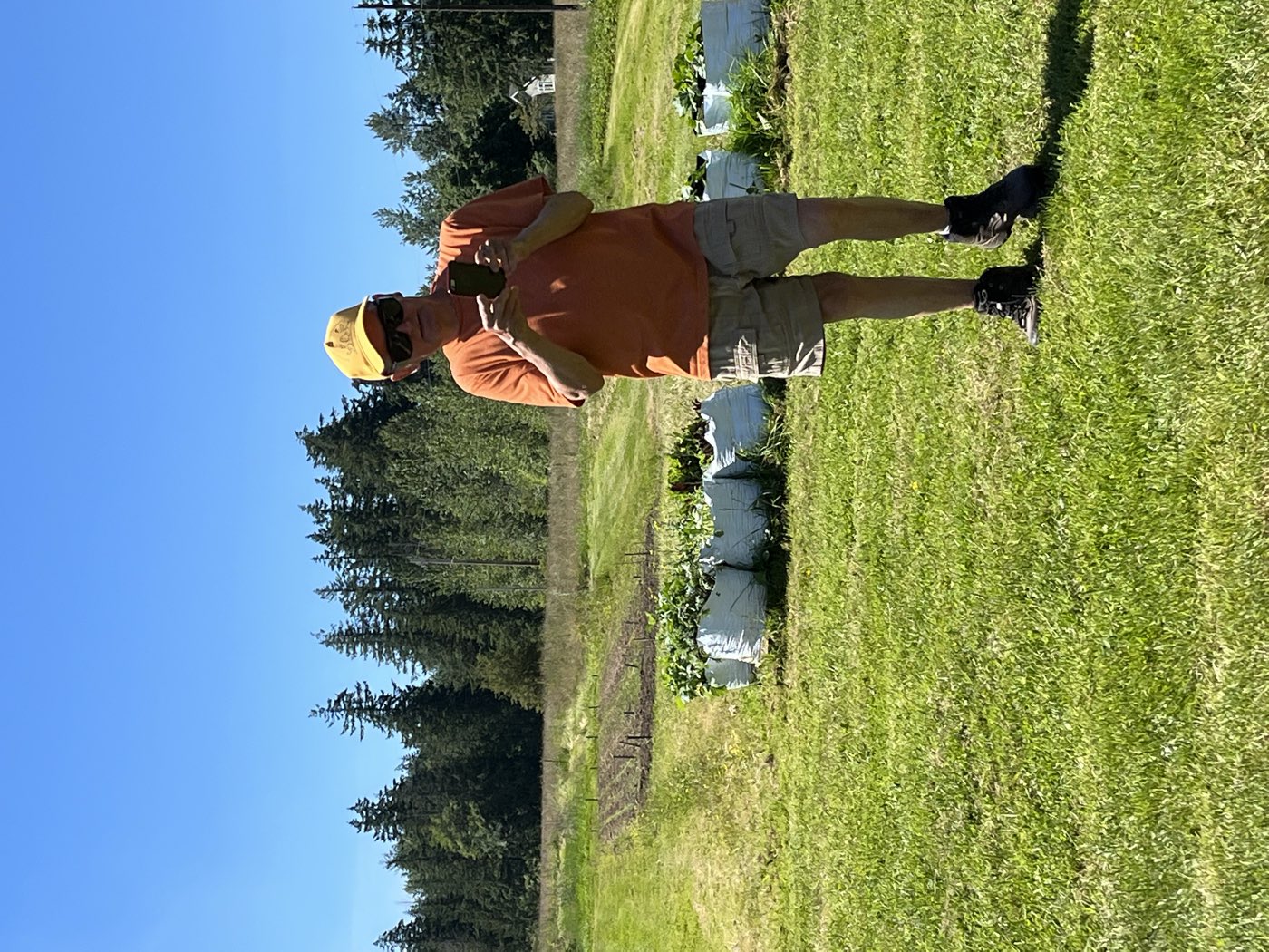 Sam Grubbs standing in the field beside the raised beds on a clear day
